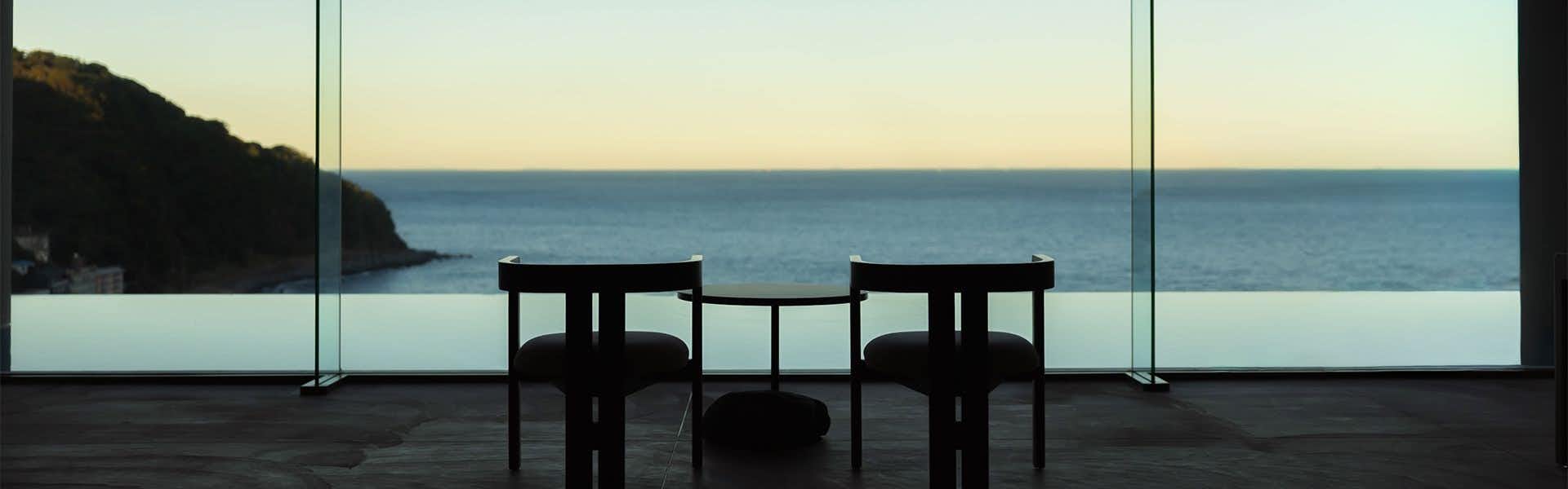 Izu Retreat Atagawa Suiko by Onkochishin (formerly Atagawa Onsen Suiko) with a dining table facing the sea.