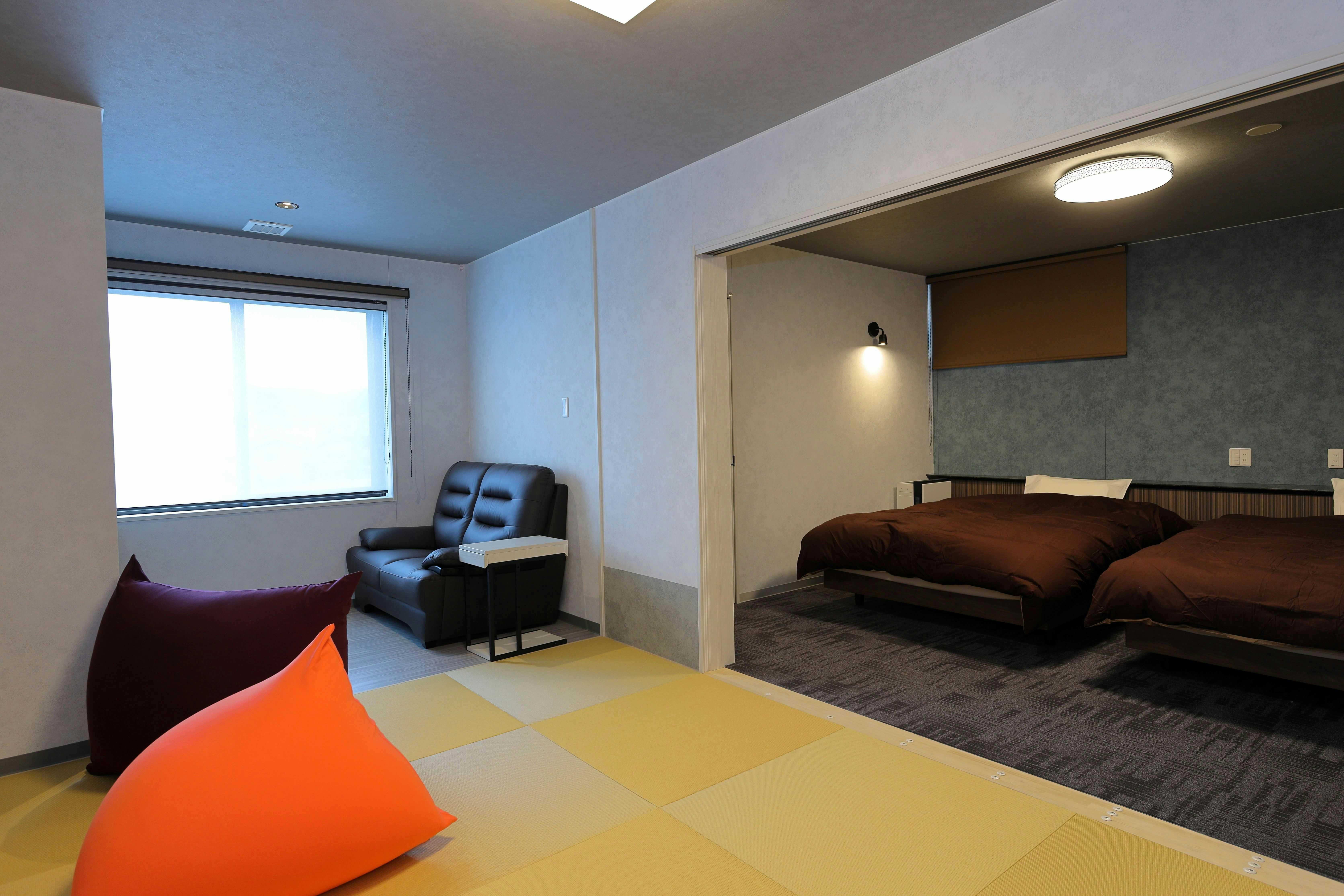 Iizaka Onsen Matsushimaya Momoka with a modern tatami suite with colorful floor cushions and bed alcove.