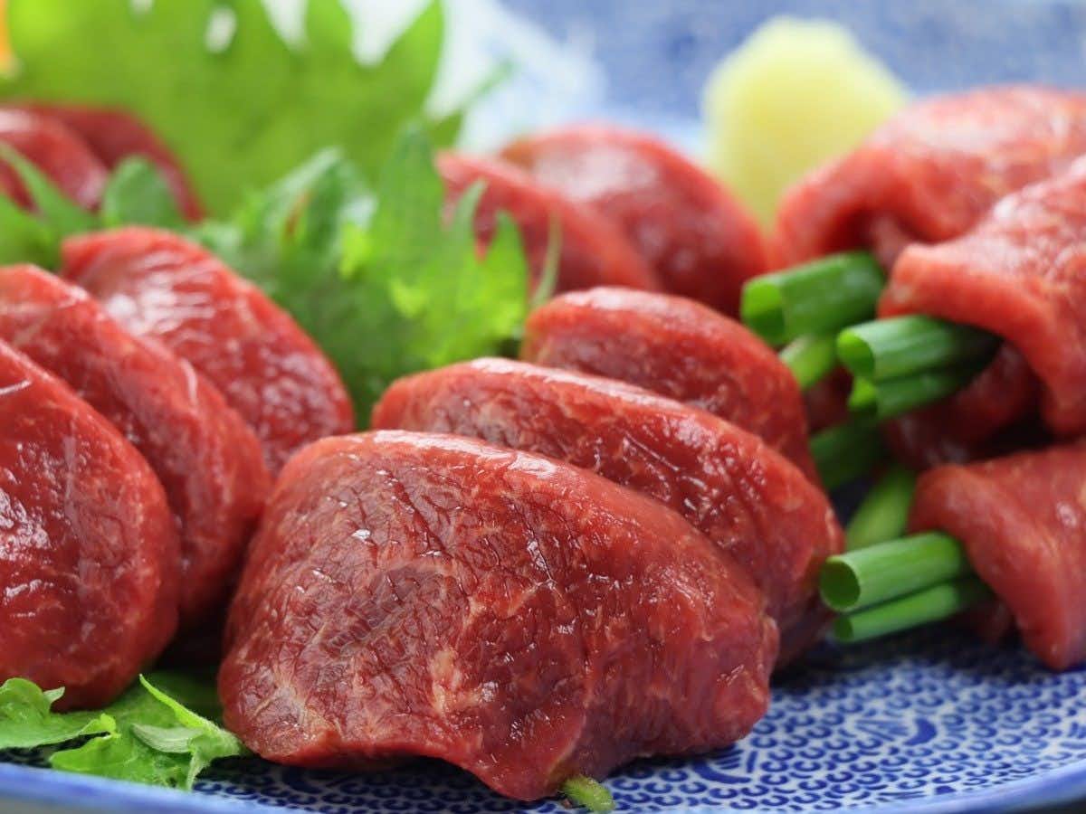 Shimosuwa Onsen Baigetsu with sliced horse meat rolled around green vegetables.