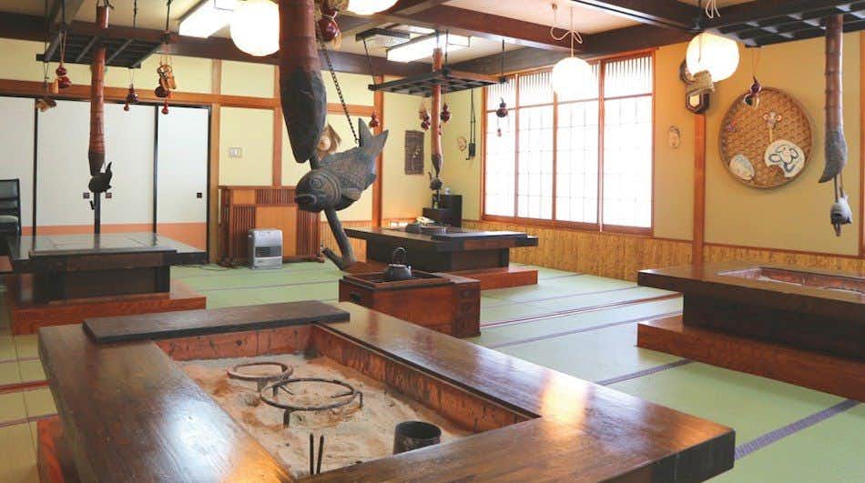 Irori Yuno Yado Osakaya with an irori dining room beneath hanging fish sculptures.