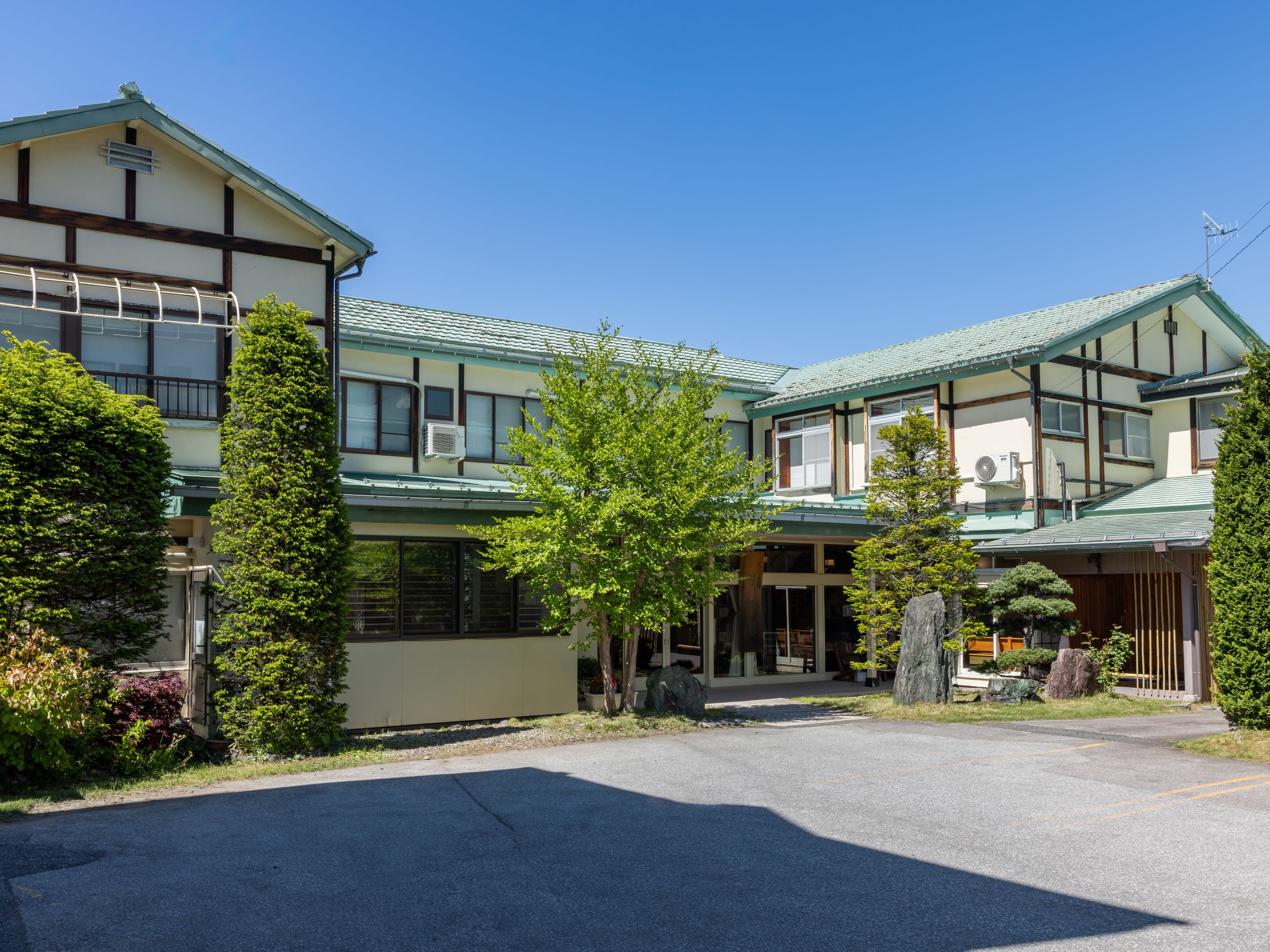 The multi-level property is set among green hills and trees.