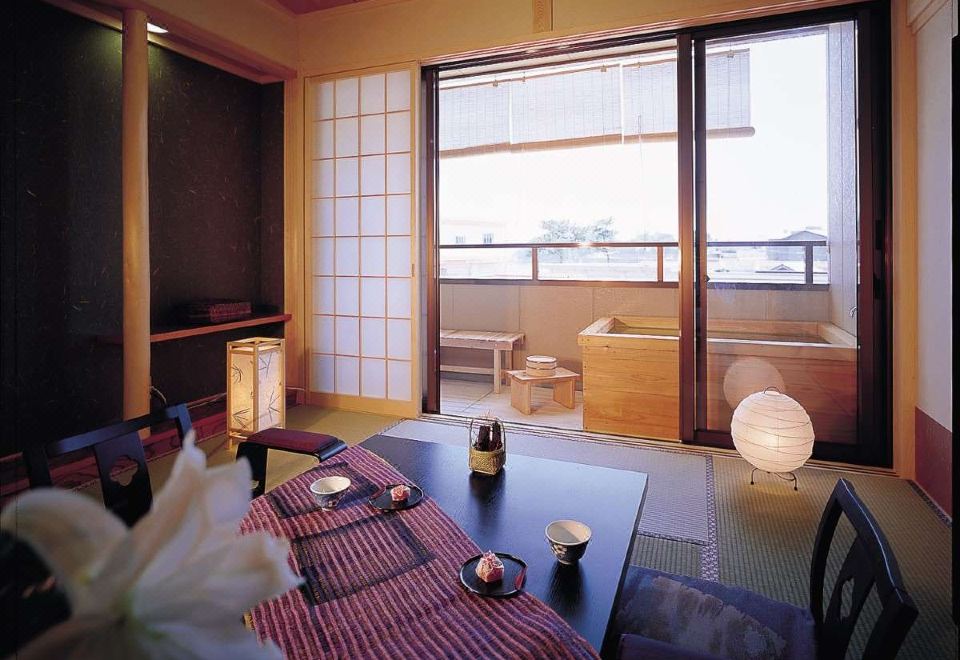 A low table and tea service in a traditional guest room opening onto a bath terrace.