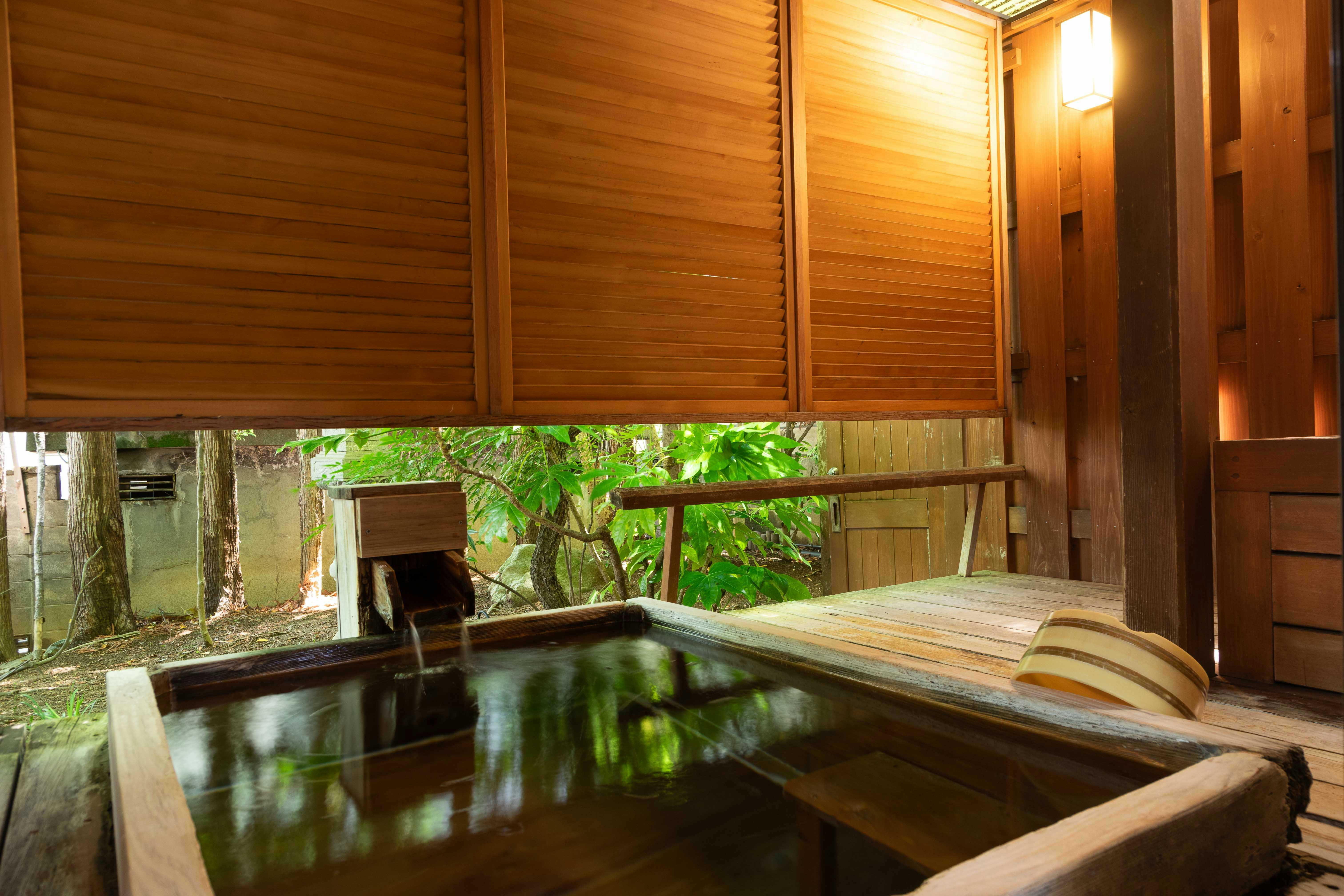 Asama Onsen Izumiso with a private timber bath overlooking a leafy garden.