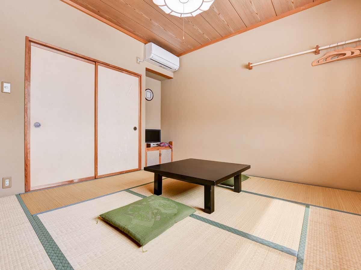 Togari Onsen Shikisai no Yado Kanoe with a simple tatami room centering a low table beneath a pale timber ceiling.