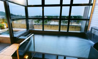 A large bath enclosed by glass walls and roof panels.