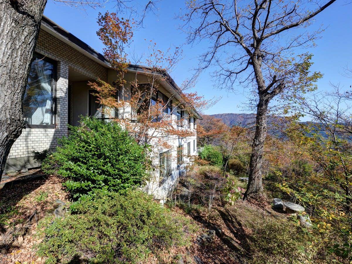 Hakone Gora Onsen Mizunokaori with the low hotel building behind autumn garden trees.