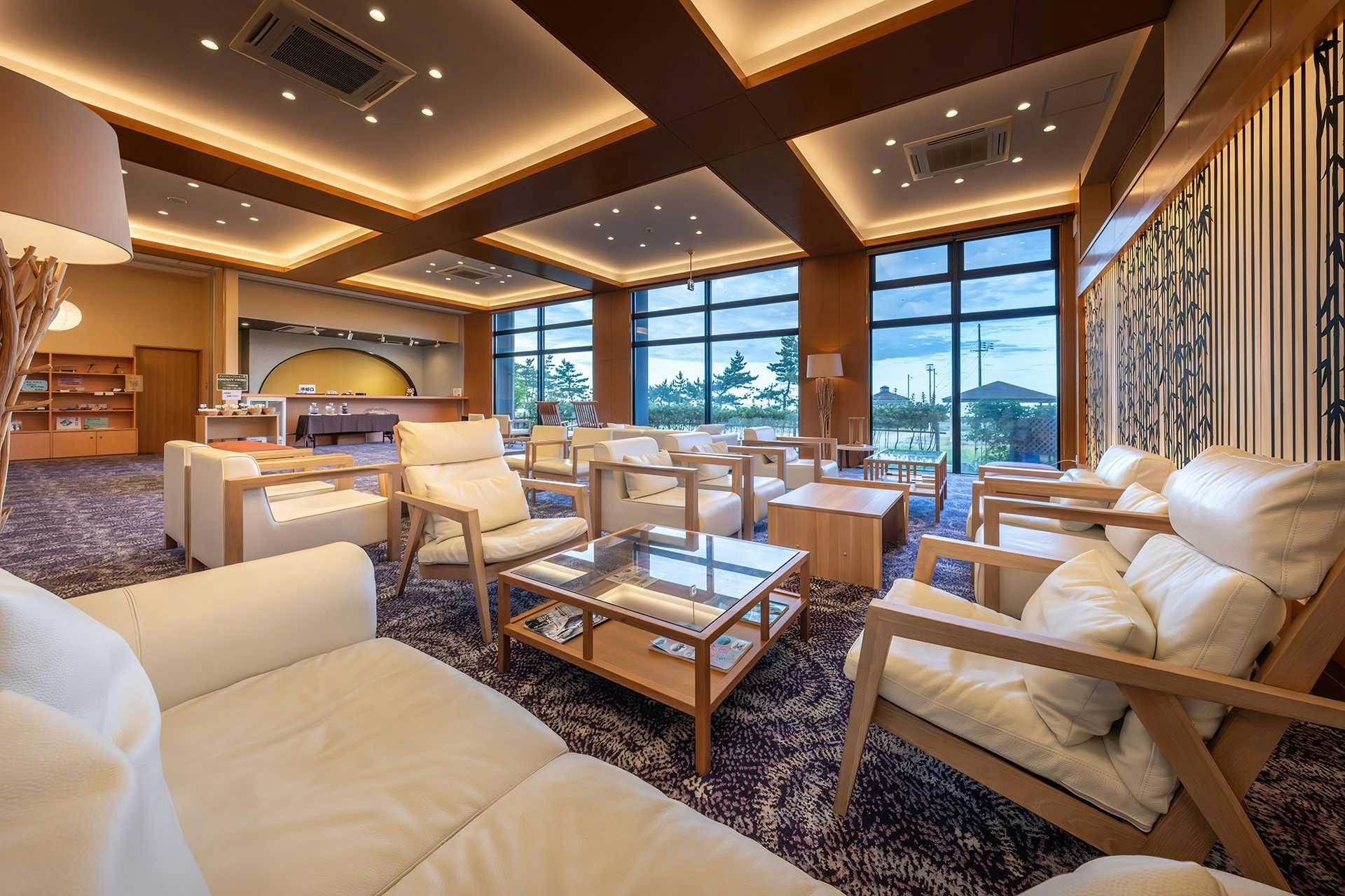 Seaside Satake with a spacious lounge with cream sofas and sea-facing windows.