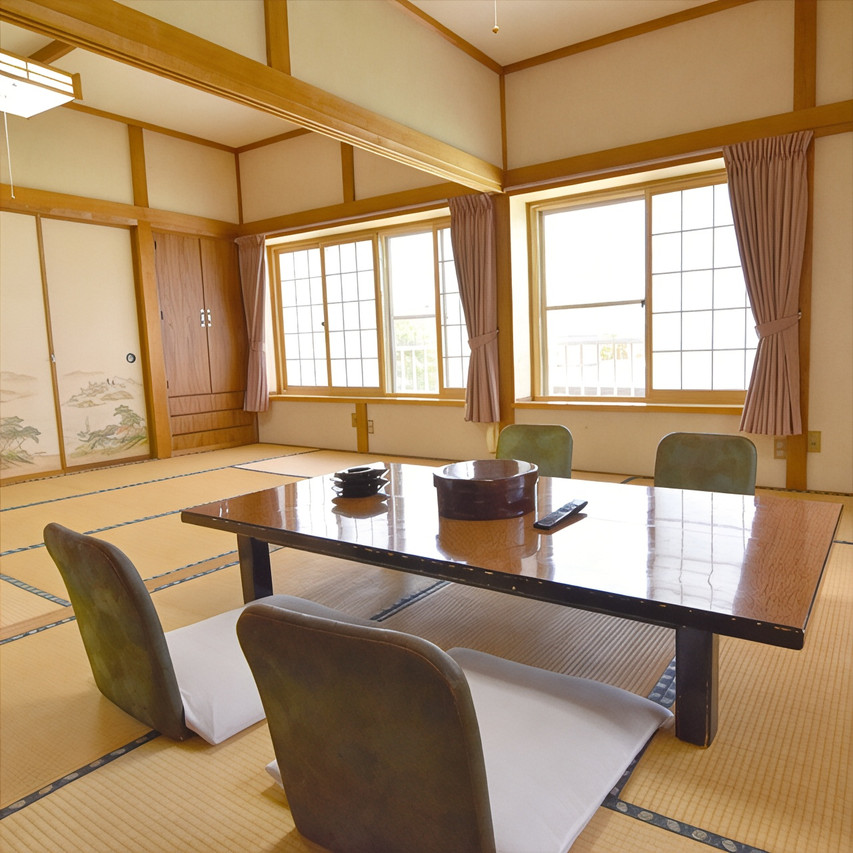 A tatami dining room has a low table and garden-facing windows.