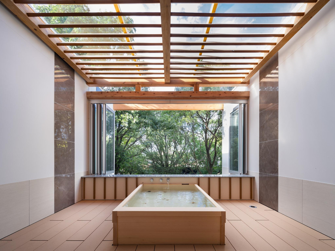 A wood-lined bath beneath a glass roof.