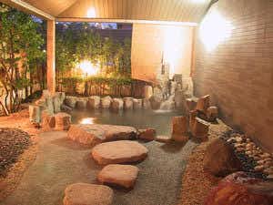 Rinkokan with an outdoor stone bath surrounded by trees and lantern light.