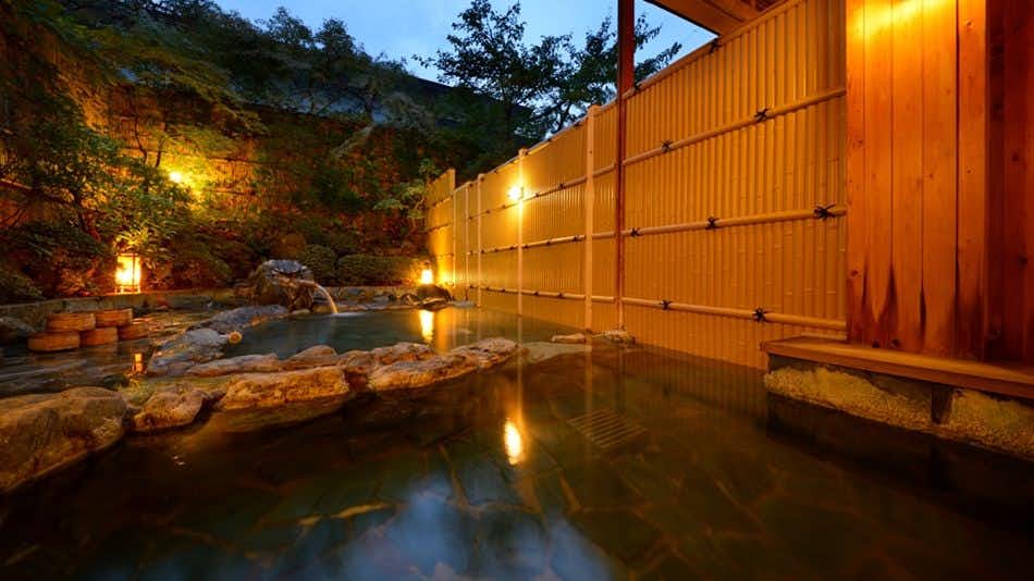 Shohakutei Azumaso rock-lined outdoor bath enclosed by bamboo walls and trees