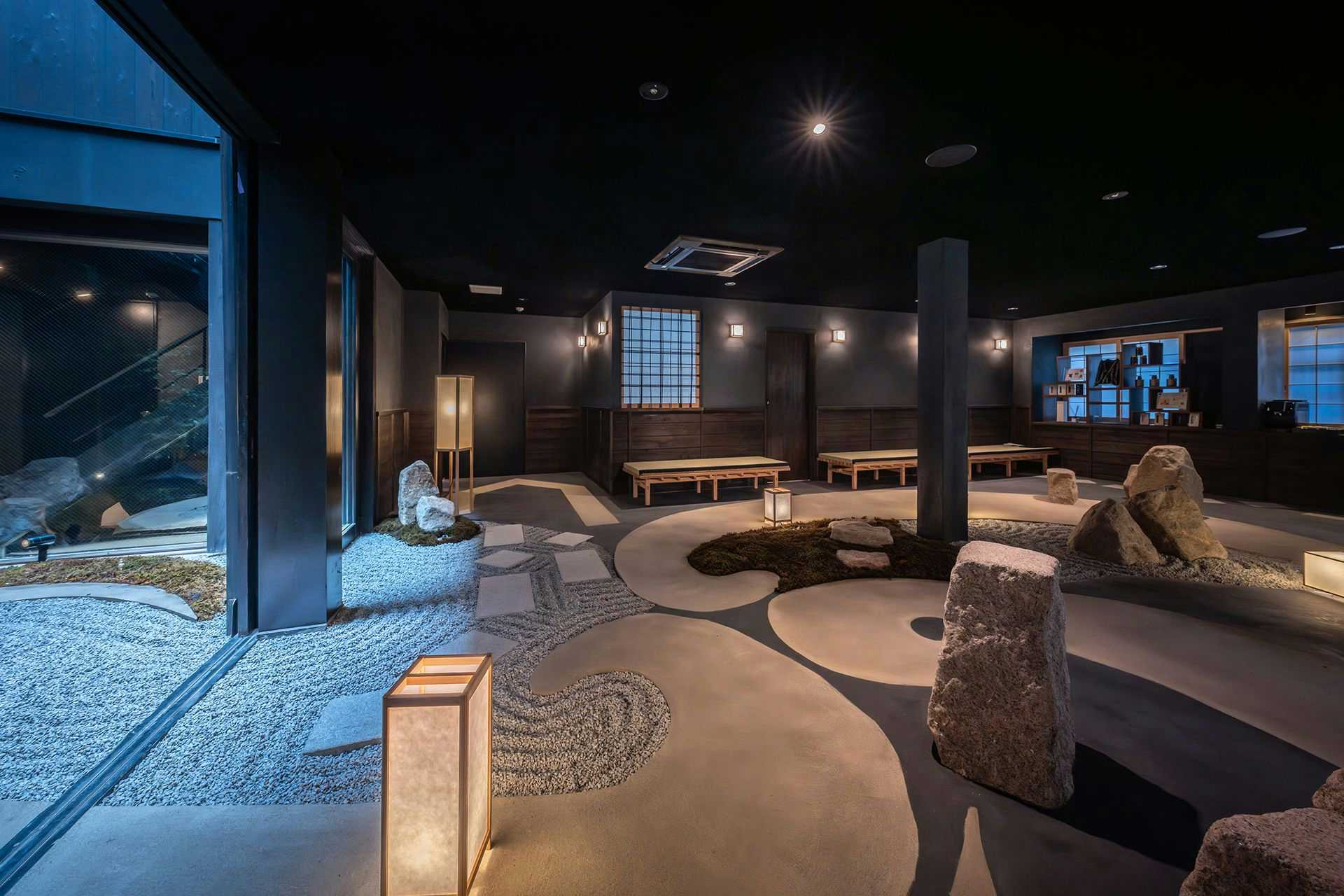 A contemporary lounge surrounding a lantern-lit rock courtyard.