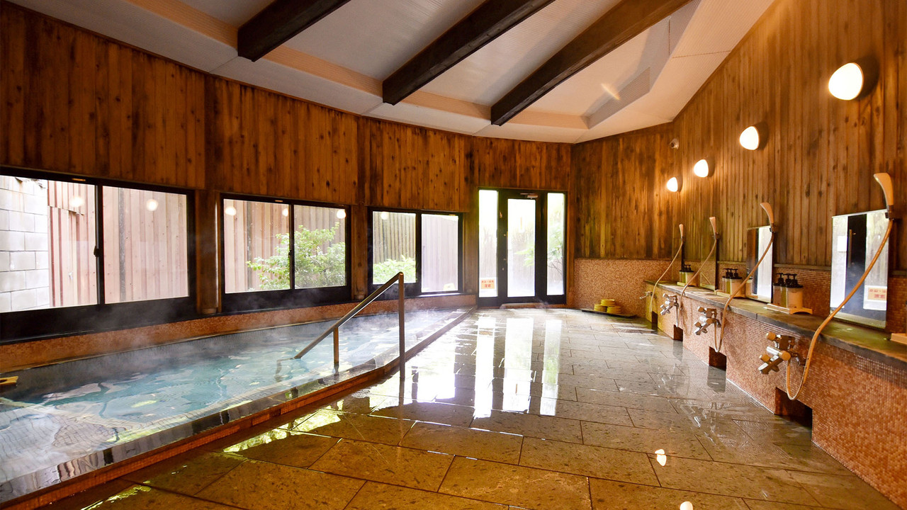 Indoor bathing pool with windows and seating.