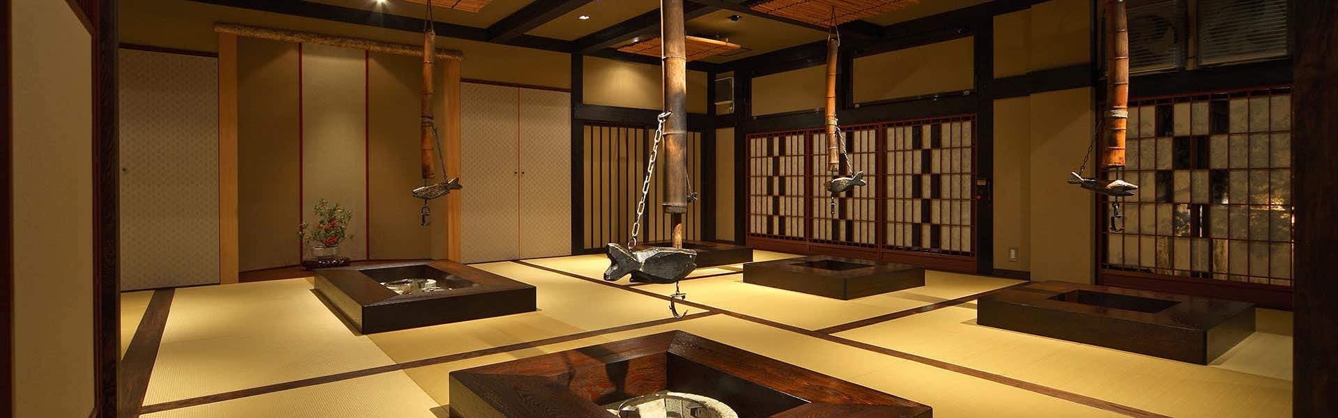Tatsumikan with this scene, where its traditional room frames a recessed hearth and dark timber details.