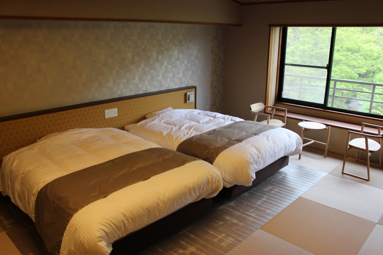 A spacious room combines beds with a wide mountain-facing window.