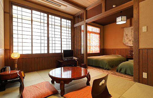 Twin beds, tatami flooring, and a round table.