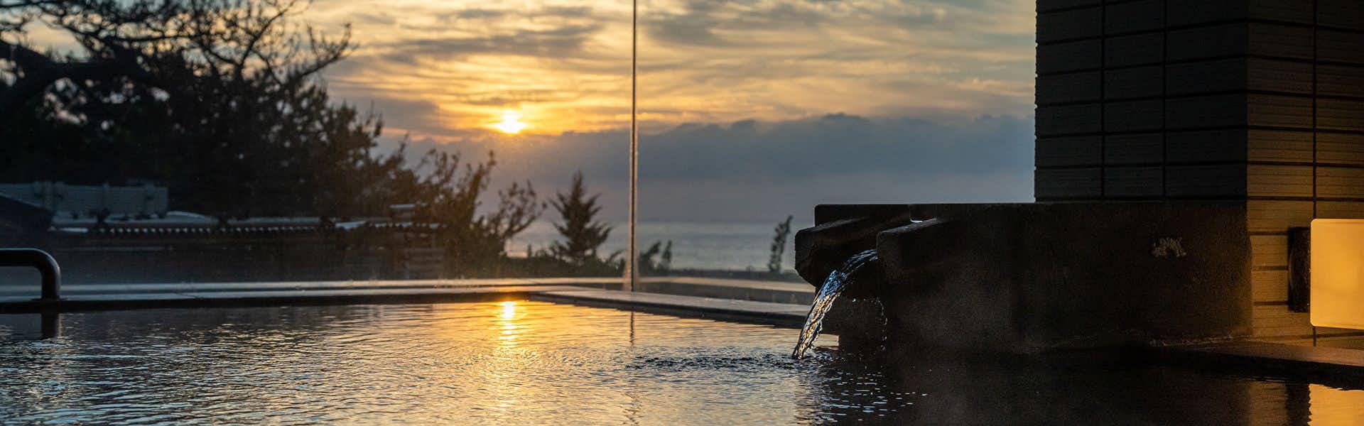 Izu Kawazu Onsenkyo Kaiyutei with an open-air bath overlooking the ocean at sunset.