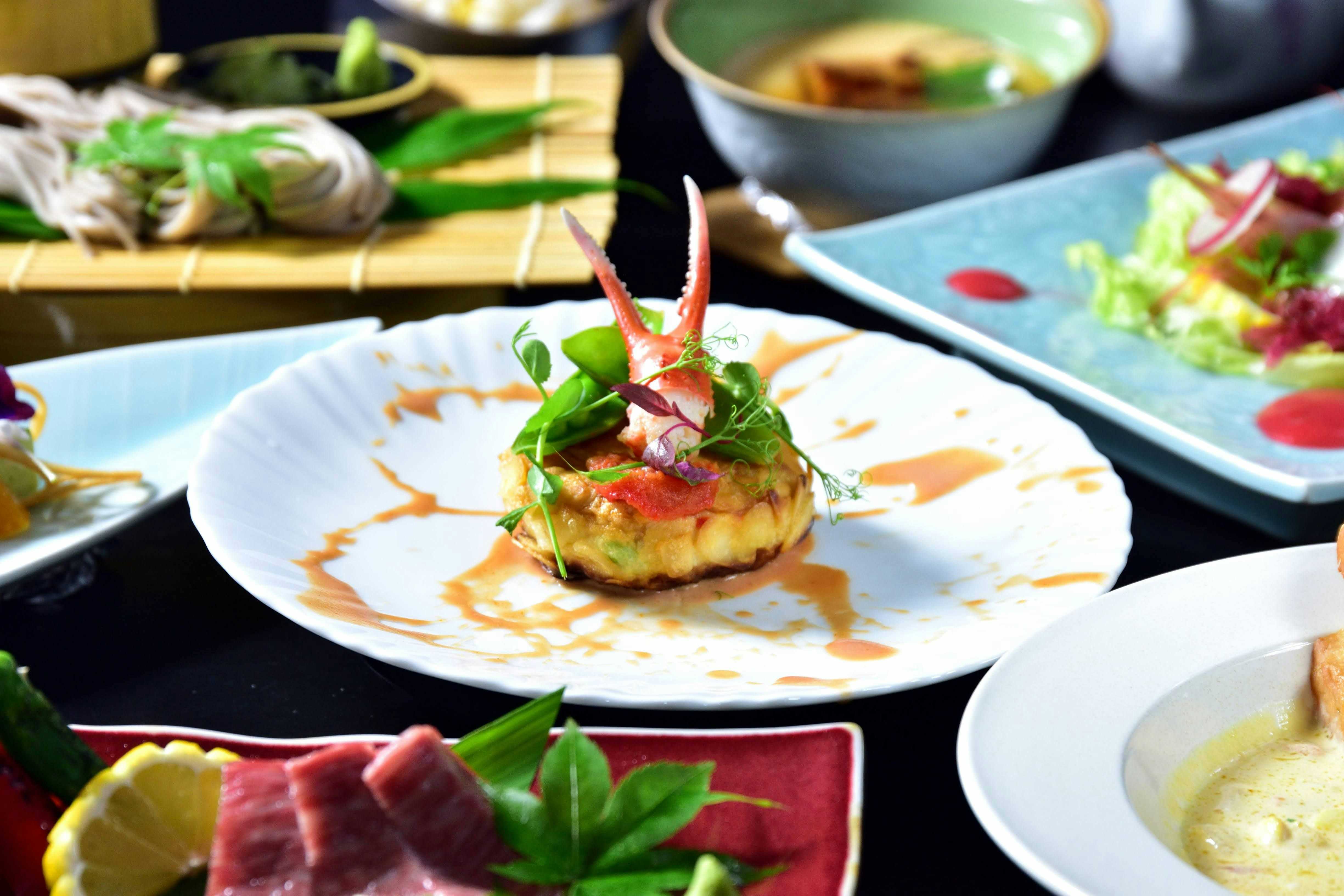 Teradomari Hokushinkan with a seasonal dinner featuring grilled fish and colorful side dishes.
