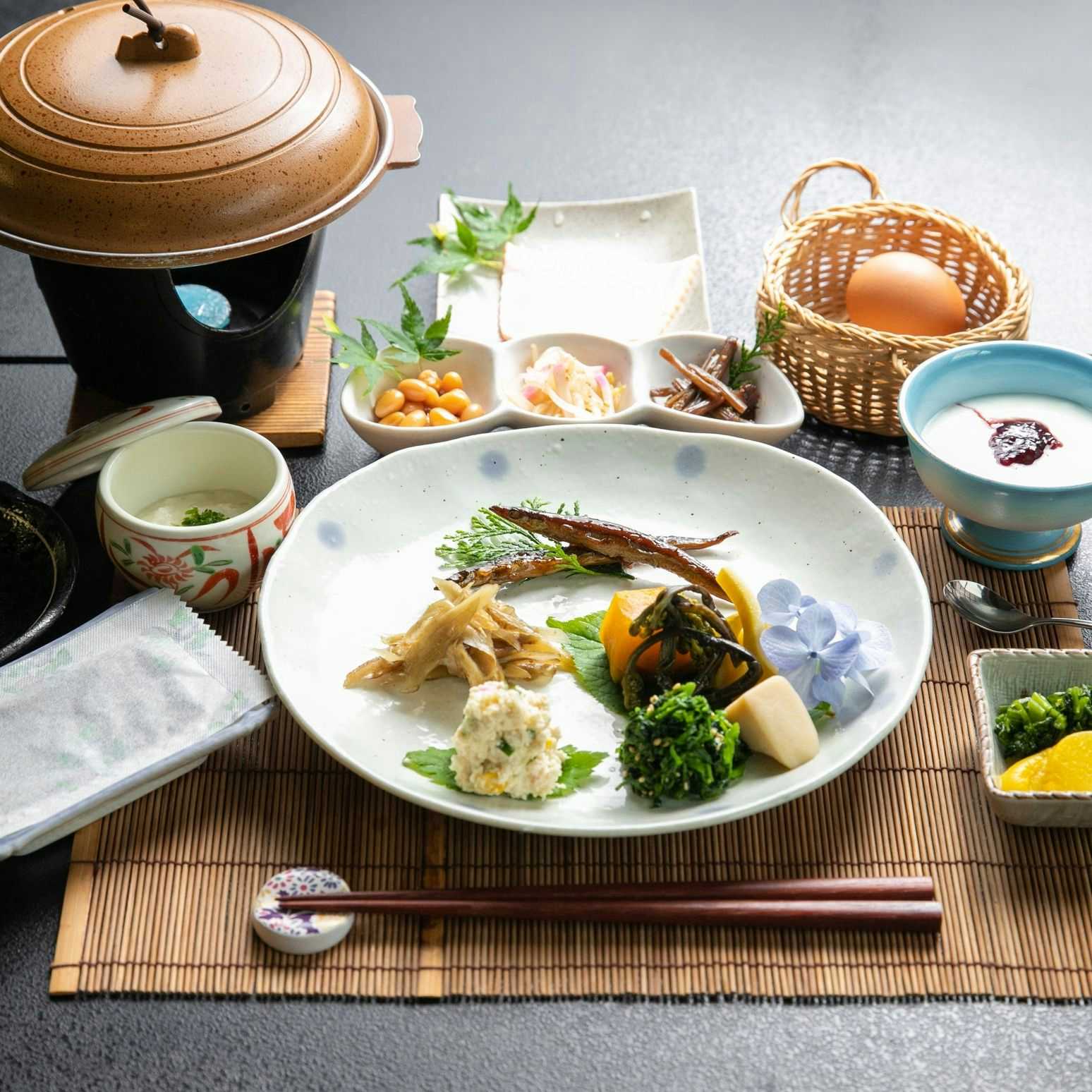 Kuyuspa Onsen Ryokan Seifuso with a seasonal dinner with fish, vegetables, rice, and a clay pot.