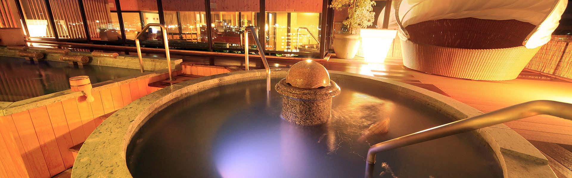 Houshoukaku with a lantern-lit open-air bath reflecting warm evening lights.