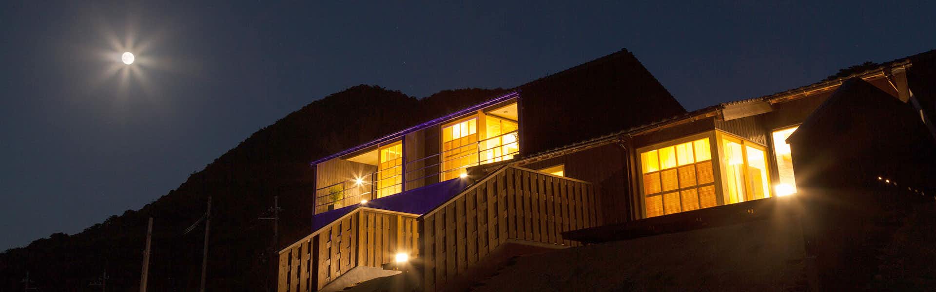 Kyo・Tango Resort Hanare Soraharu Traditional wooden building with illuminated windows against twilight sky and moon