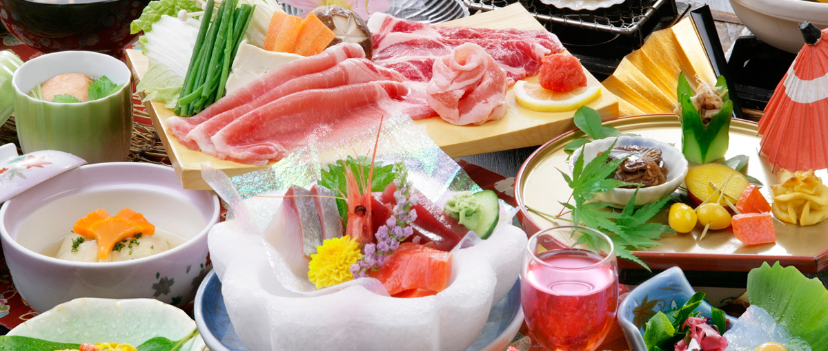 Sashimi, sliced pork, vegetables, and small dinner dishes.