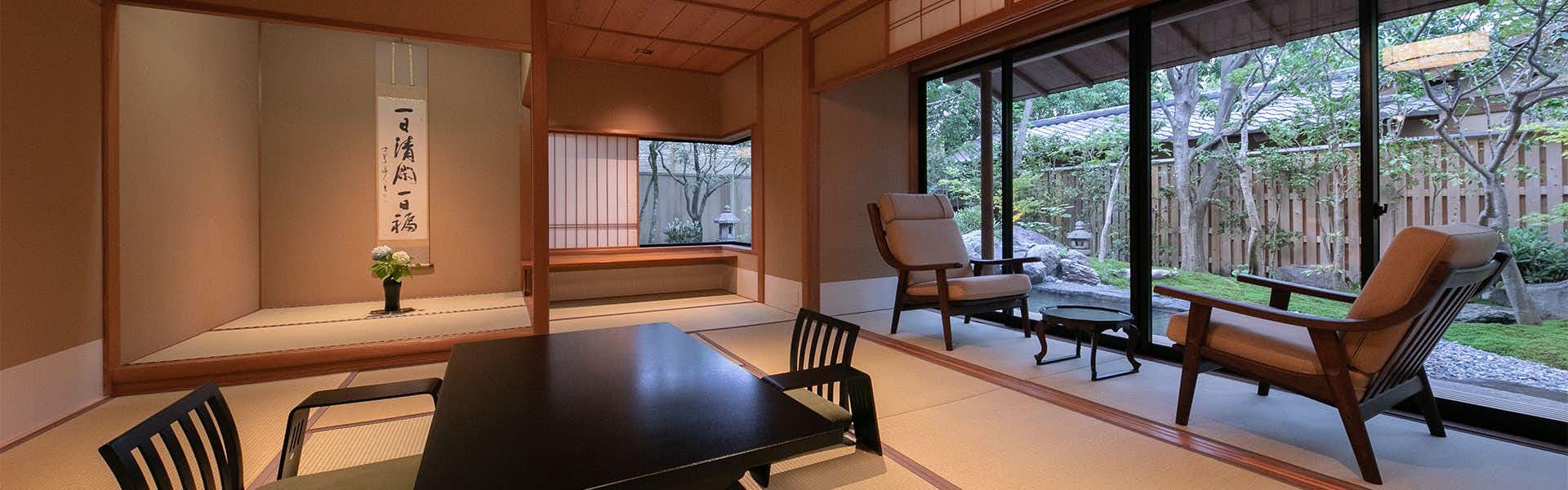 Suki no Yado Yakakutei with a traditional tatami room opening toward garden lounge chairs.