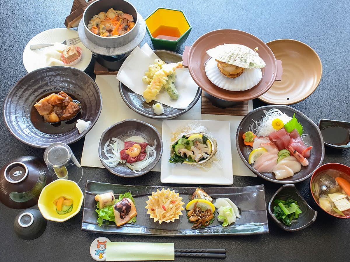 Ryokan Kaikokan with a multi-course seafood dinner presented across colorful dishes.