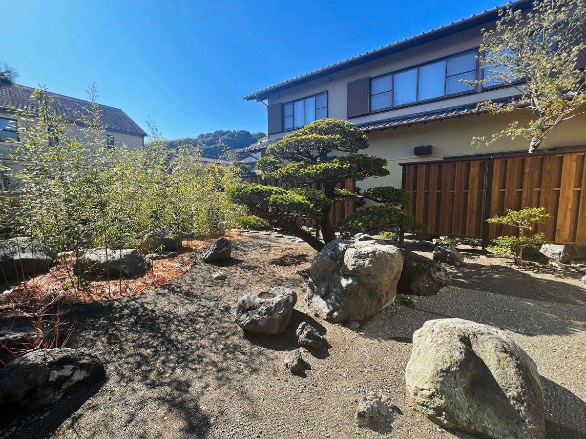 Kappo Ryokan Okaya with a landscaped courtyard garden beside the low guesthouse buildings.