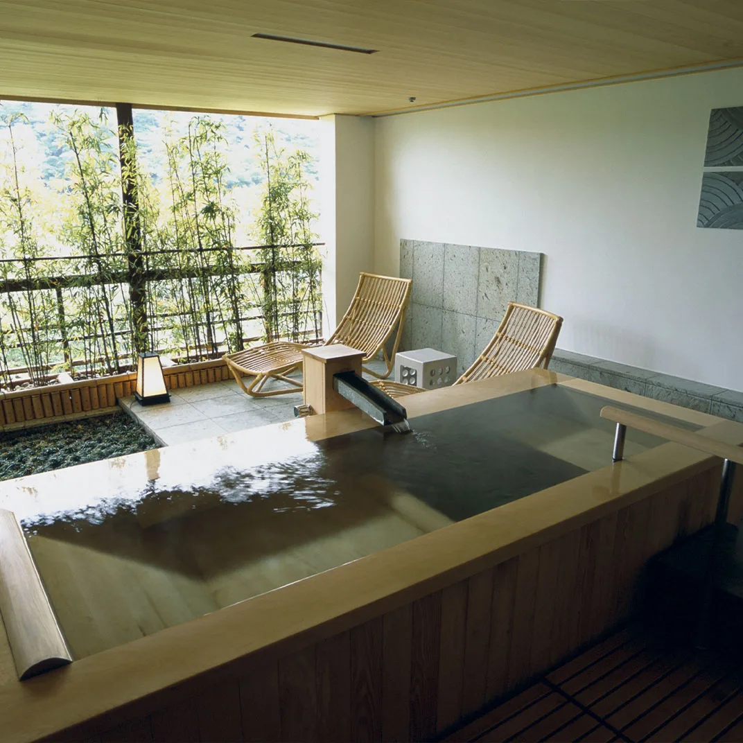 Private in-room hinoki onsen bath with bamboo garden view at Gora Kadan
