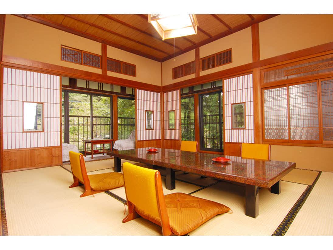 Mountain Lodge Nagisa with a spacious tatami room with orange chairs and garden windows.
