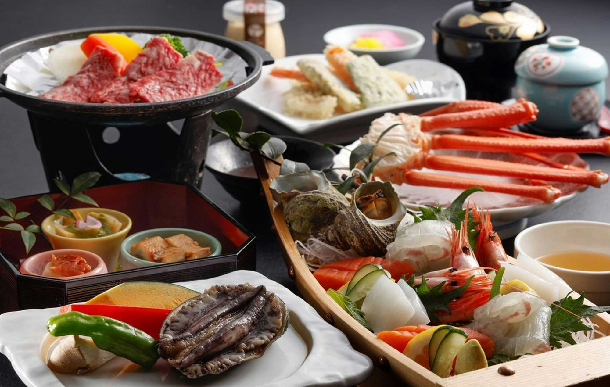 Kinosaki Onsen Ryokan Oyado Hakusan with a Japanese dinner centered on crab, grilled beef, and seafood.