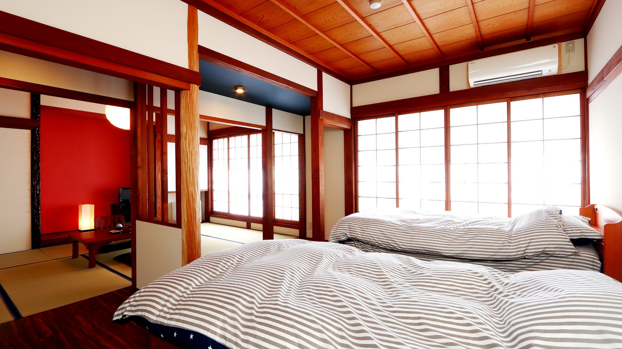 A room with beds beside a wood-paneled wall.