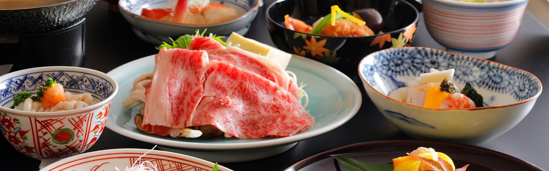 Waqoo Horyuji with marbled beef and seasonal dishes arranged across a dining table.