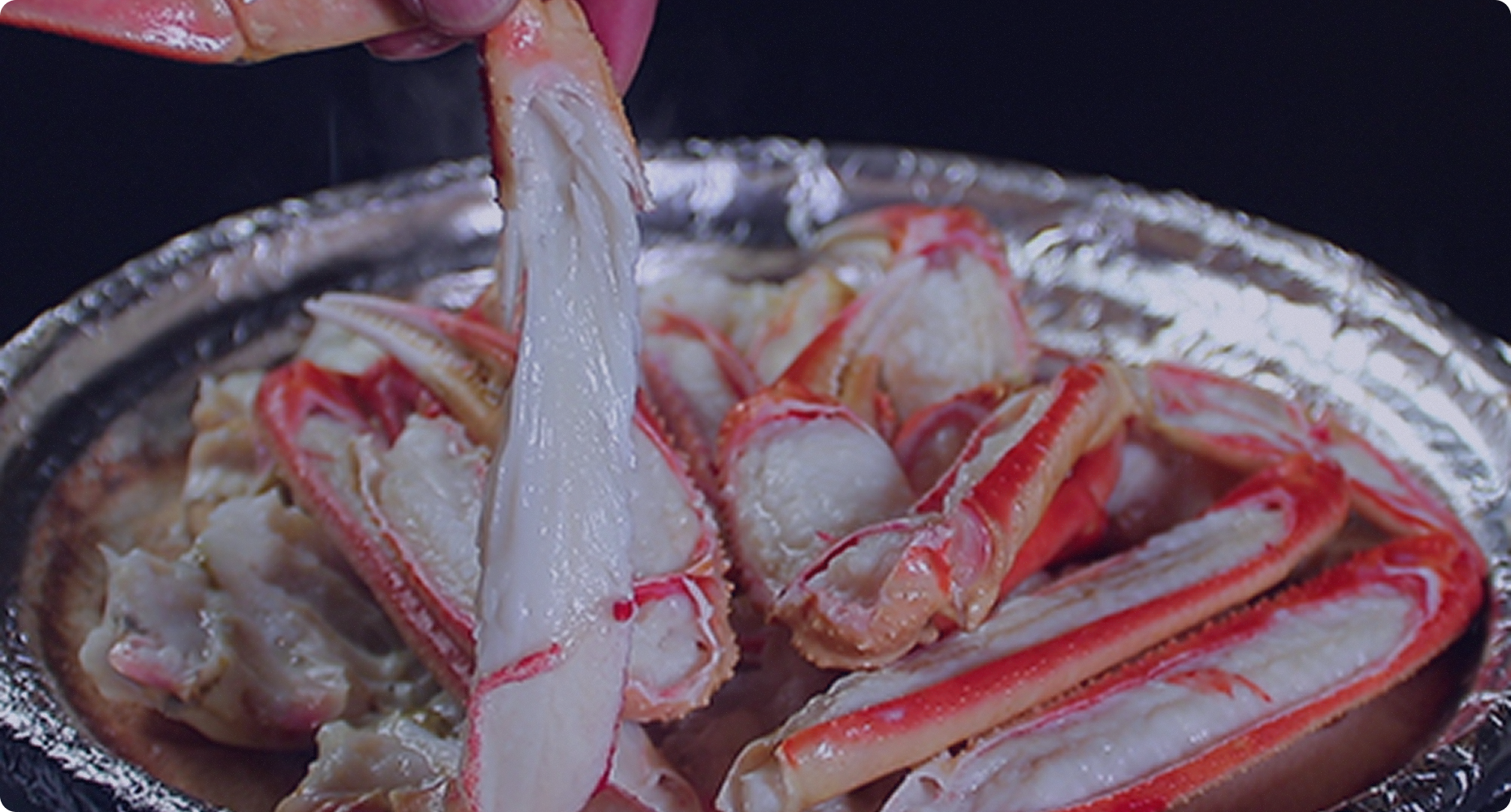 Crab legs served in a metal bowl.