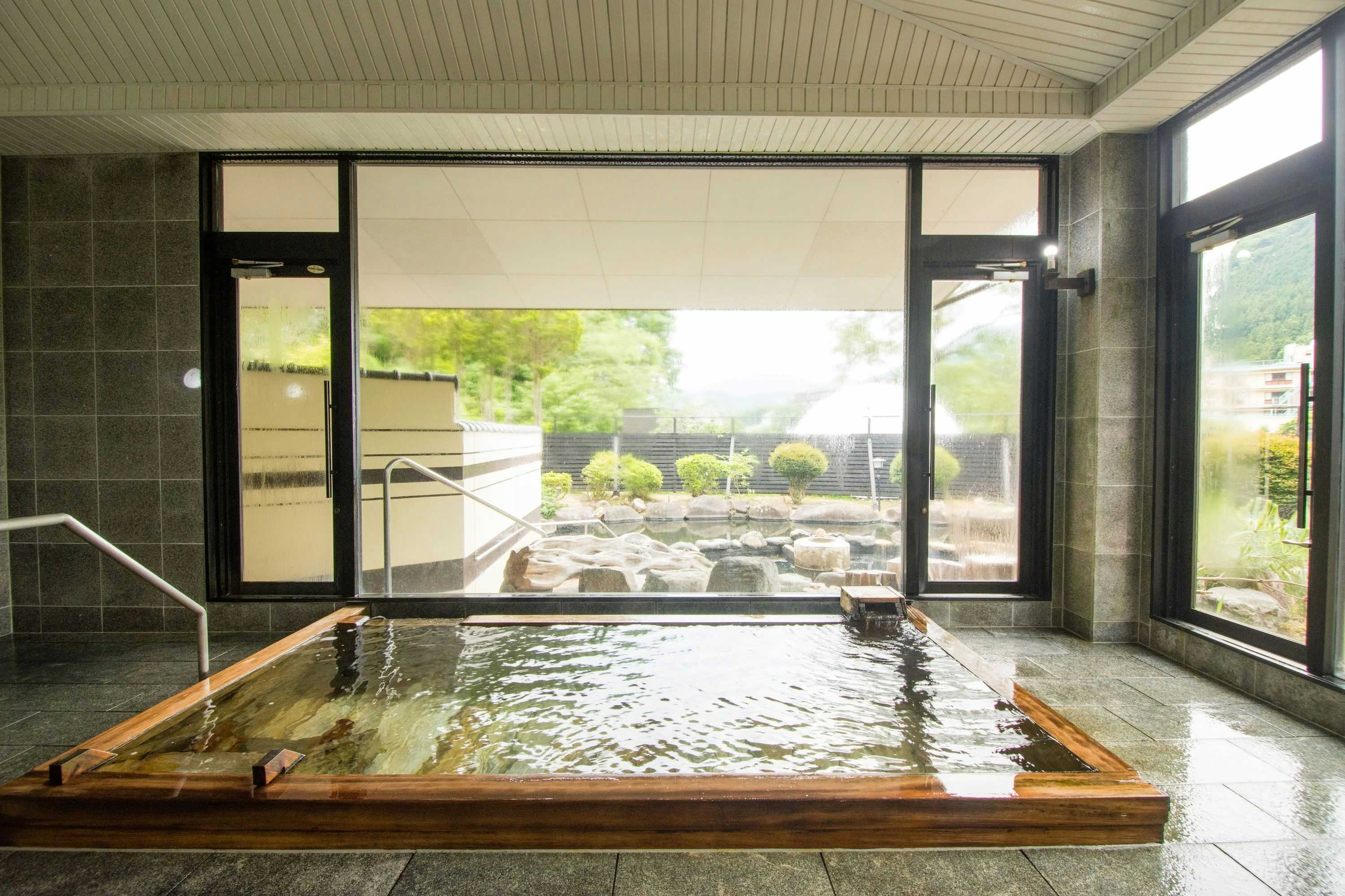 Akasawa Onsen Ryokan with a bright indoor mineral bath overlooking a rock garden.