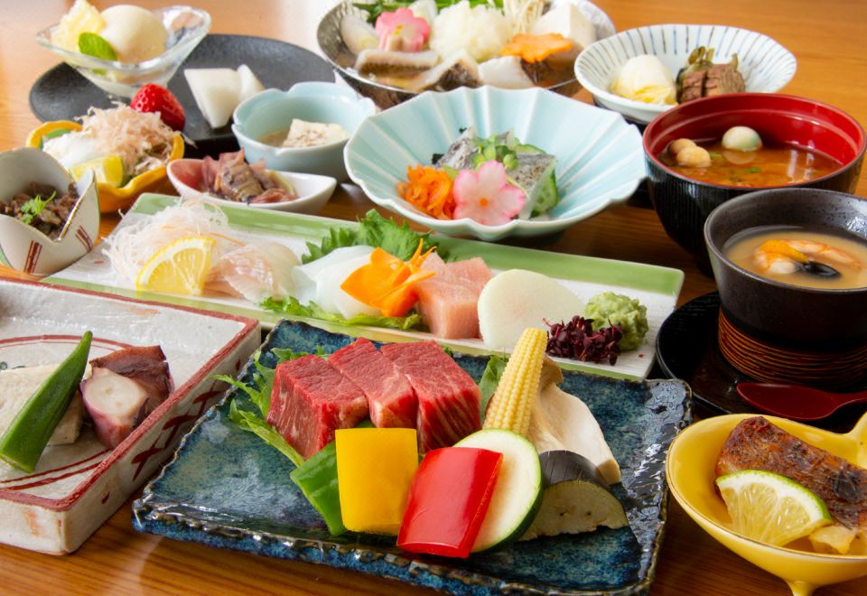 A meal of sashimi, beef, vegetables, and small dishes.