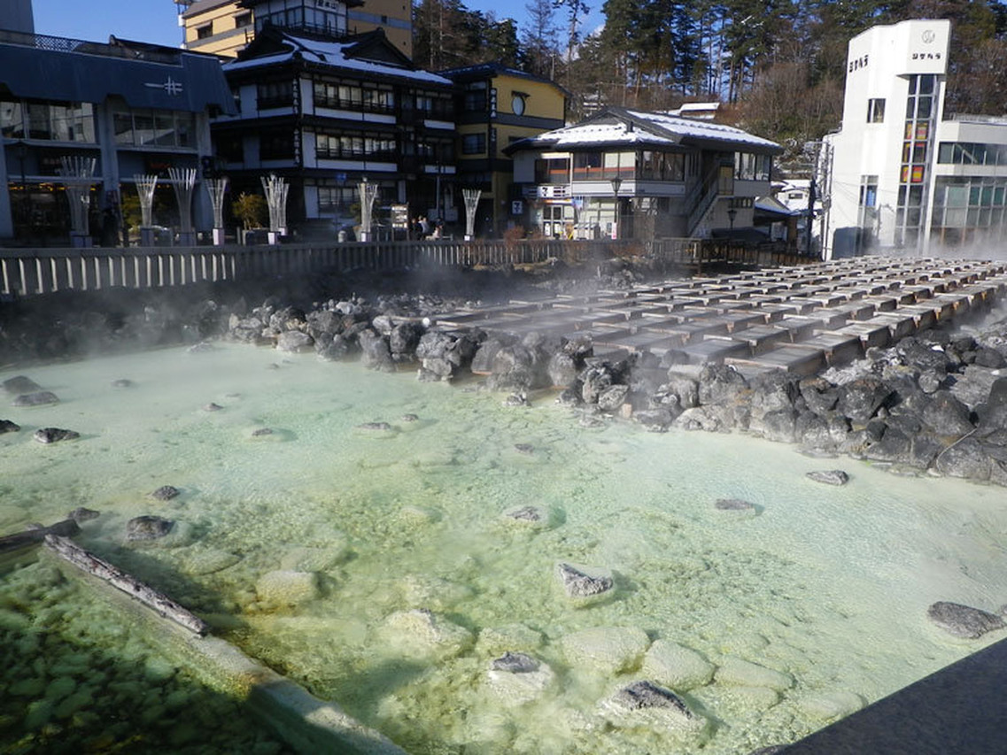 Outdoor hot spring pool beside a stream.
