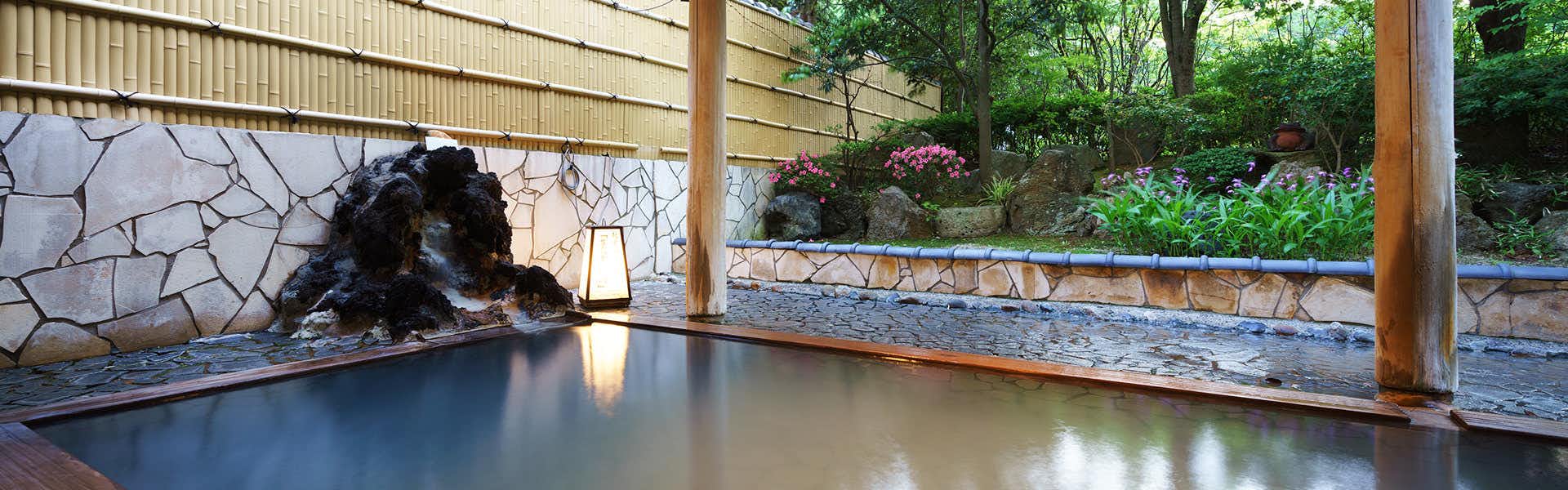 Accommodation Overlooking the Echigo Plain and Yahiko Mountain Range - Hoho - with an open-air bath facing a landscaped garden.