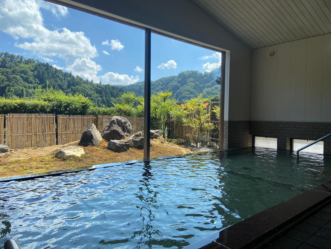 A bathing pool reflects the wooded landscape beyond the windows.