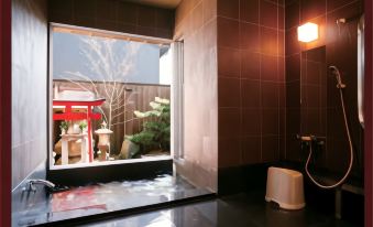 A tiled bathing room overlooking a small garden.