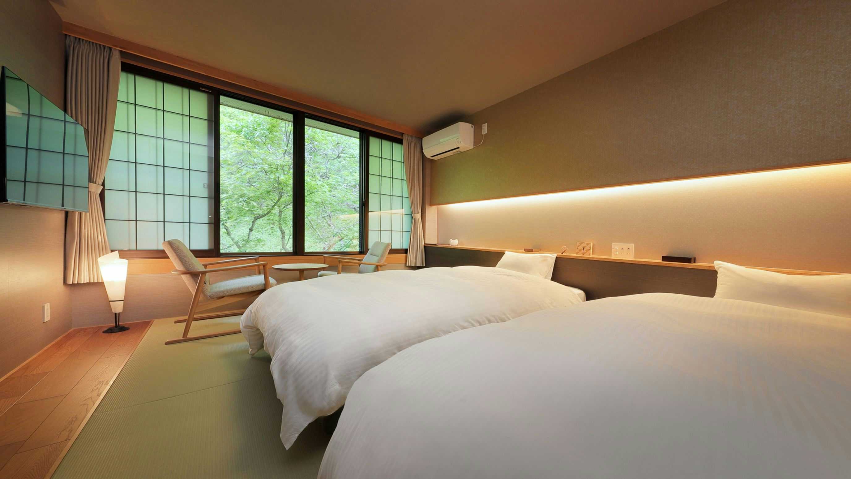 Bandai Atami Onsen Yunoyado Rakuzan with two beds, green window view, wood trim, and pale walls