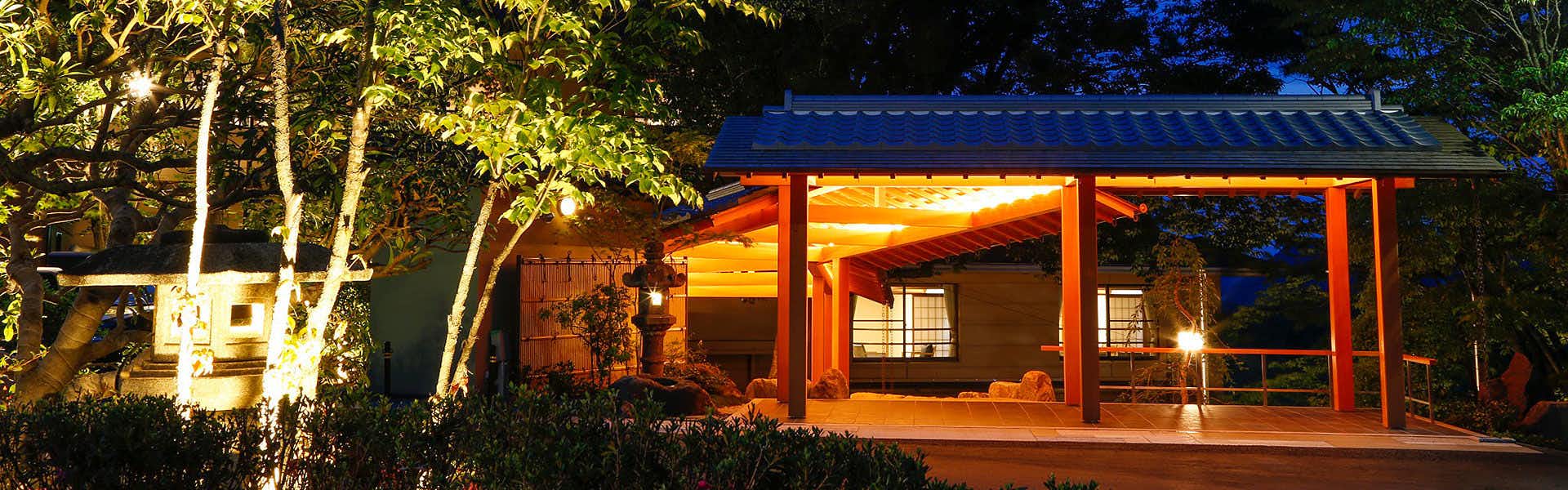 SPA TERRACE Shisui with an illuminated garden pavilion beneath dense evening trees.