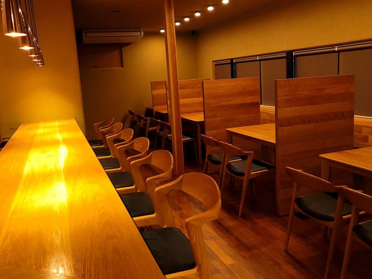 Nakanoya Ryokan with a long timber dining counter beneath pendant lights.