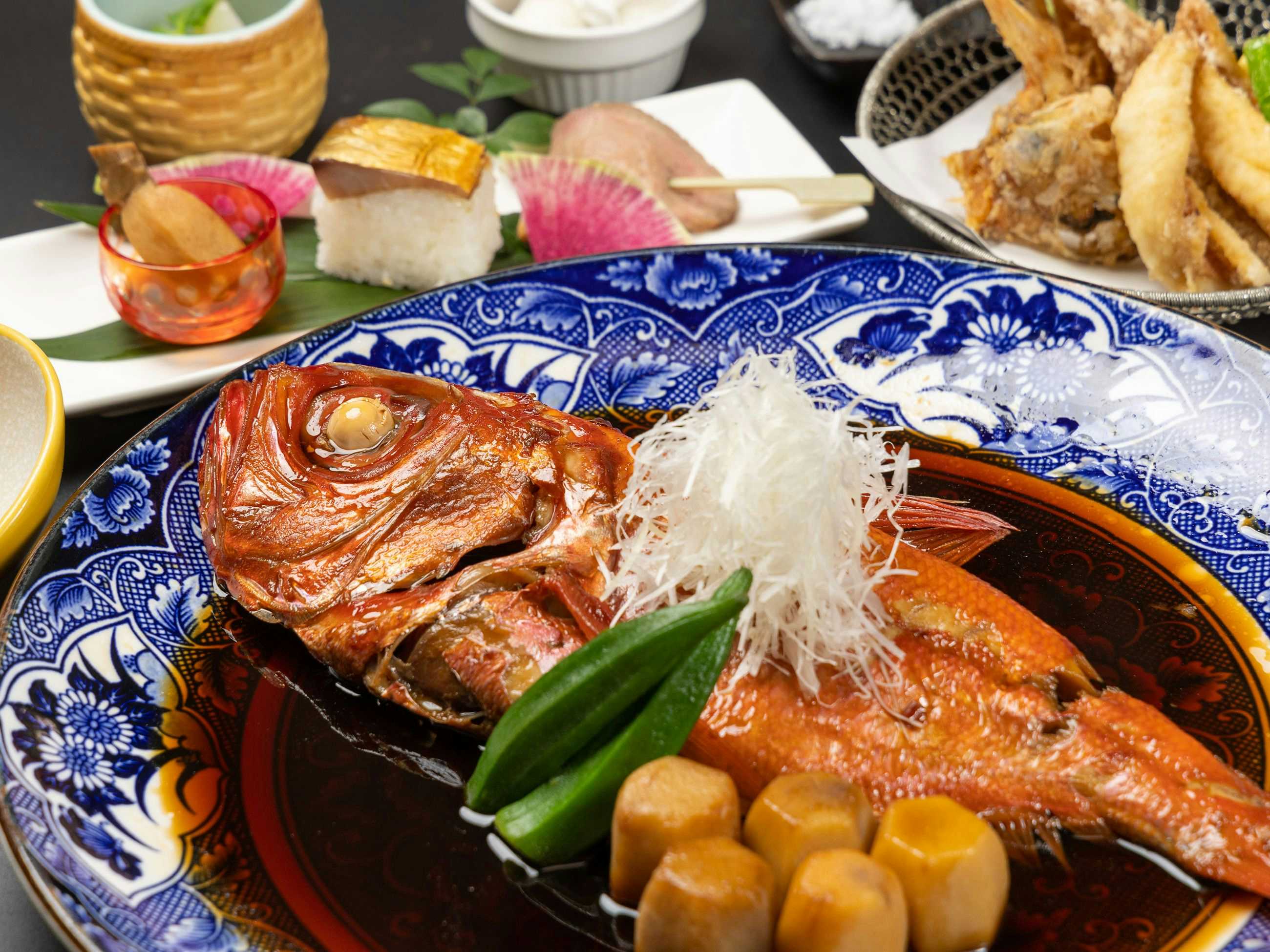 Hotel Yoshino with a whole simmered fish served on blue patterned tableware.