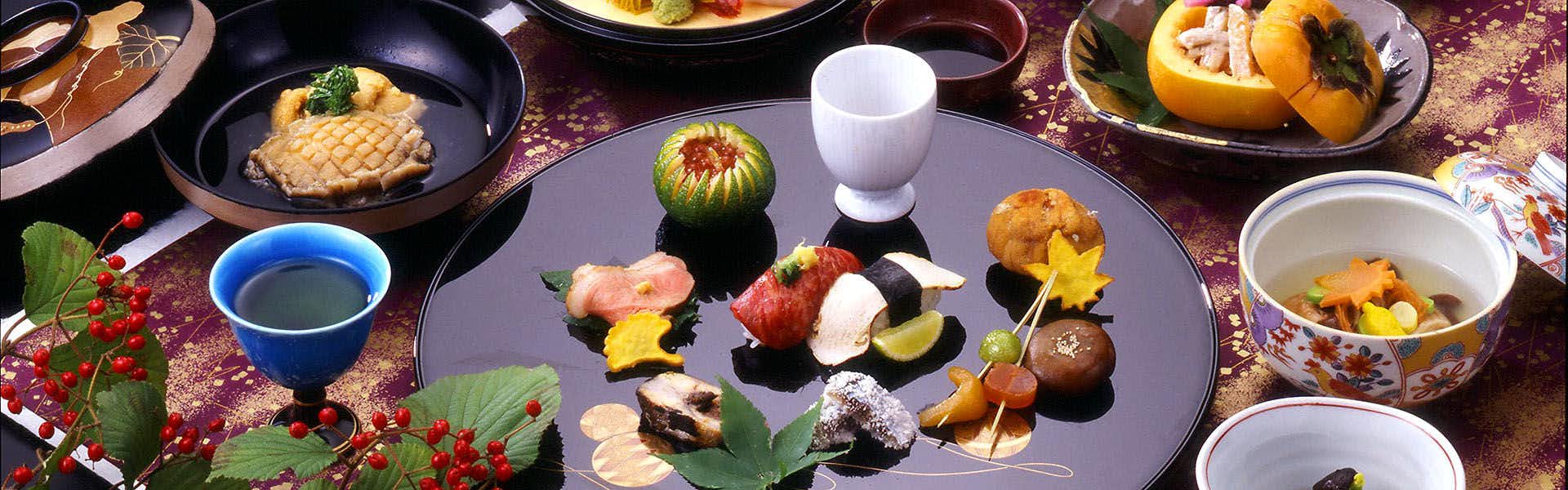 Morioka Tsunagi Onsen Shikitei with colorful seasonal appetizers arranged across dark ceramic tableware.