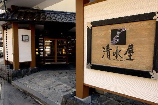 Oyado Kiyomizuya with the traditional timber entrance glowing along a quiet village street.