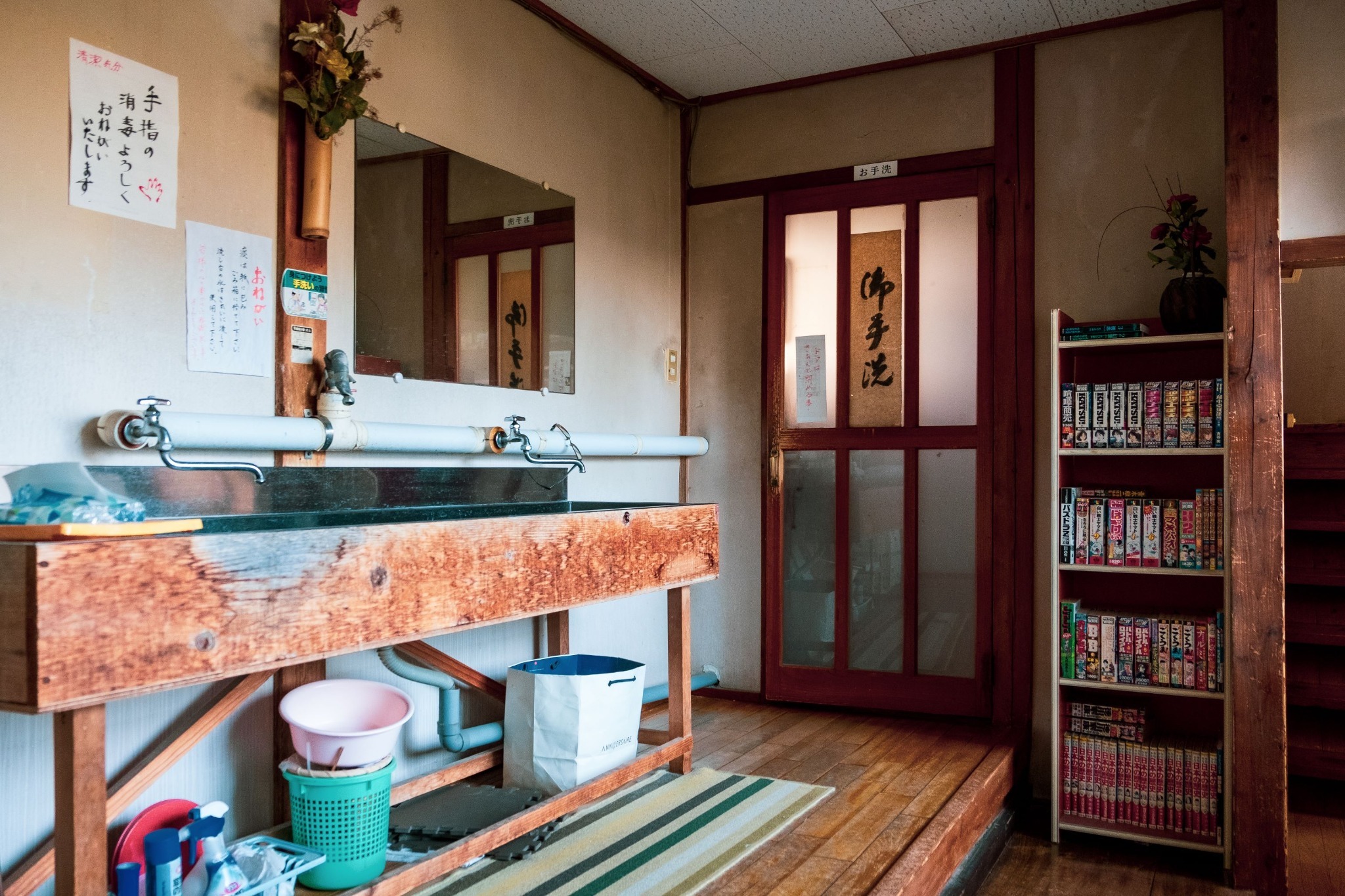 A washstand with a stone basin sits beside an entryway.