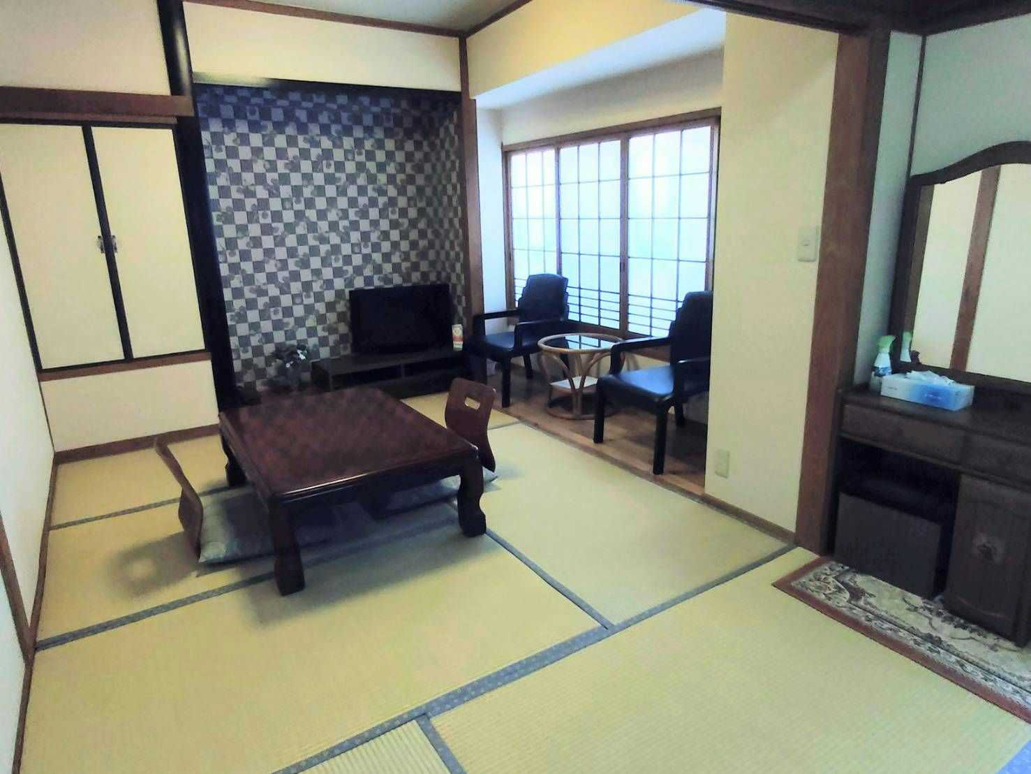Ryokan Miyakoya a tatami sitting room with a dark feature wall and low table.