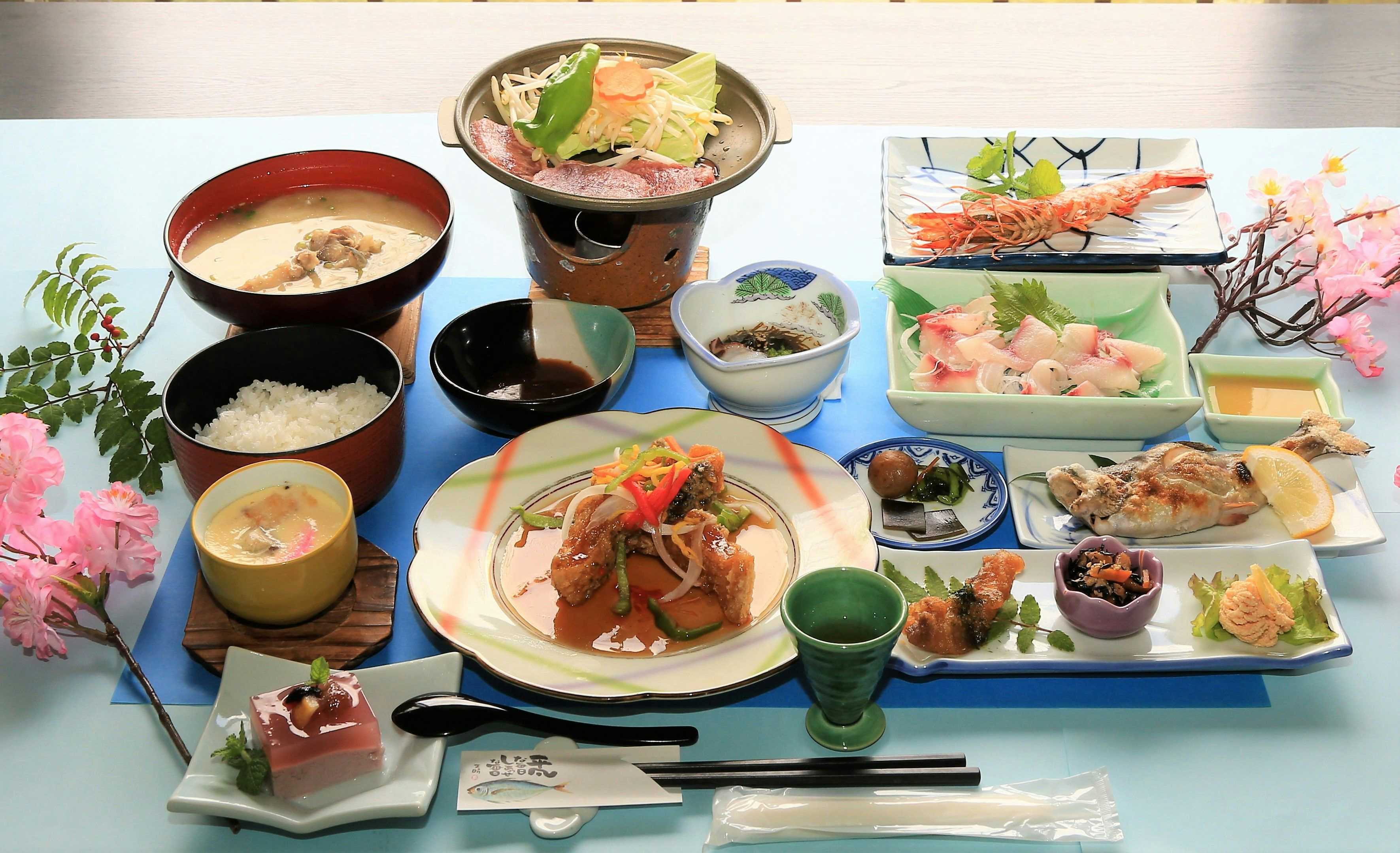 Kakuto Onsen with a complete Japanese dinner served across colorful plates.